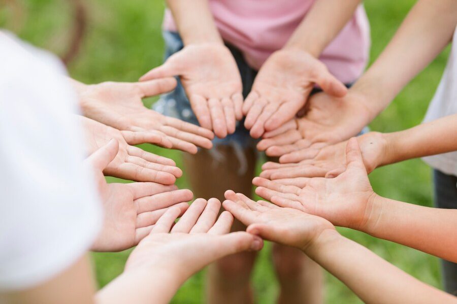 High angle friends making a flower with their hands